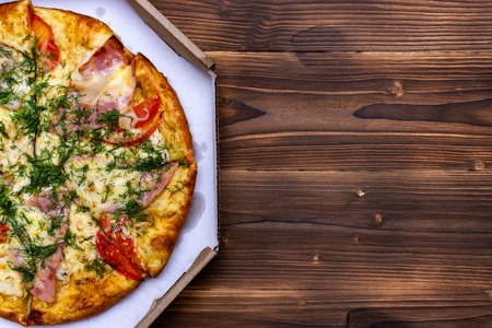 Pizza with tomatoes. Top view on wooden table with copy space for your textの写真素材