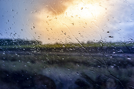 the sun shines through the fog on the glass and drops of waterの写真素材