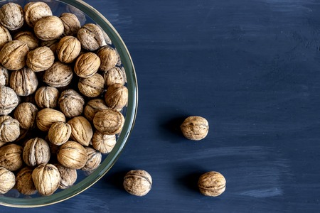 Walnuts in a glass plate on a dark background.の写真素材