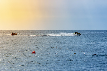 Man drive freestyle jet ski at summer sunset. Summer background.の写真素材