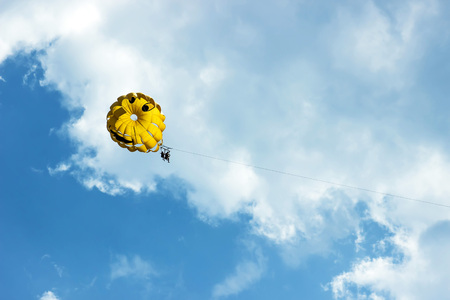 Two people are gliding using a parachute on the background of the blue sky. Summer background.の写真素材