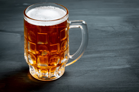 Mug with beer on black background.の写真素材