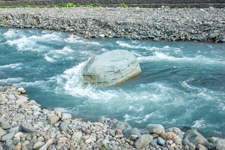 flow of water and spray from a stone close upの写真素材