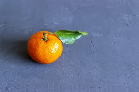 Fresh tangerines with leaves on black stone background. Top view. Copy space.の写真素材