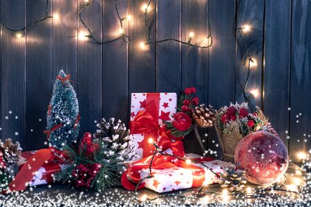 Gift boxes and garland lights over old wooden background. Christmas and new year conceptの写真素材