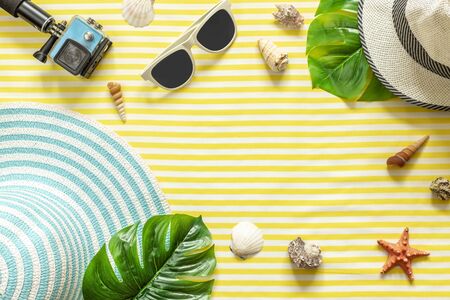 Summer composition. Tropical palm leaves, hat, action camera on yellow background. Summer concept. Flat lay, top view, copy spaceの写真素材