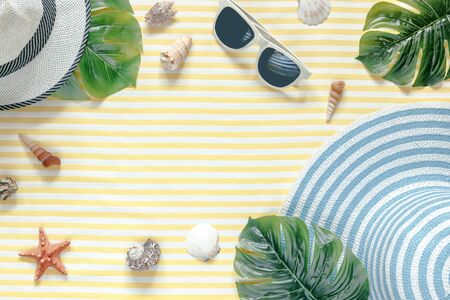Summer composition. Tropical palm leaves, hat, sunnglass on yellow background. Summer concept. Flat lay, top view, copy spaceの写真素材