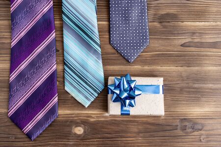 Set of stylish men accessories, mens fashion, necktie and gift box on white wood background. The...