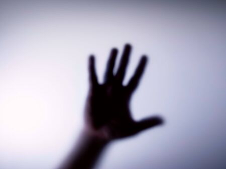 Blurred silhouette of hands and the inscription for stop