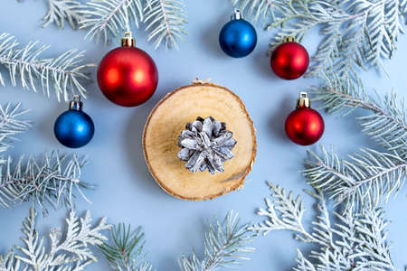 Thuja and spruce branches with a red and blue Christmas ball on a blue background. Top view. Place for text.の写真素材