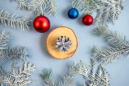 Thuja and spruce branches with a red and blue Christmas ball on a blue background. Top view. Place for text.の写真素材