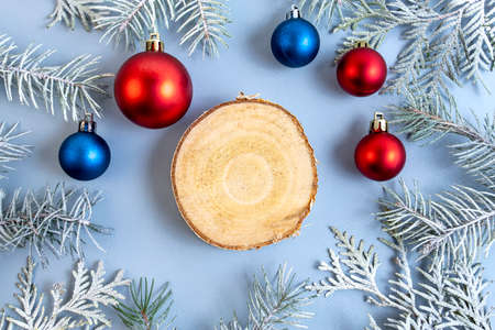 Thuja and spruce branches with a red and blue Christmas ball on a blue background. Top view. Place for text.の写真素材