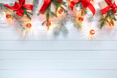 Christmas decoration of fir branches, New Year's lanterns and gifts on a white wooden background. Top view. Flat layの写真素材