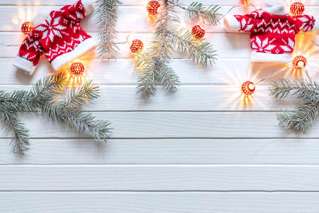 Christmas decoration of fir branches, New Year's lanterns and gifts on a white wooden background. Top view. Flat layの写真素材