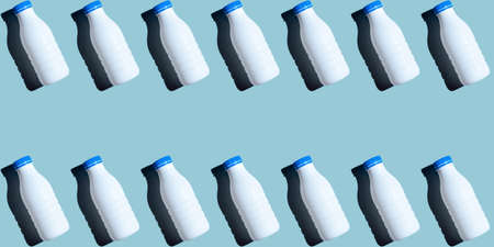 Seamless a pattern of white bottle milk isolated on uniform blue background. Banner size. Healthy food and drinkの写真素材