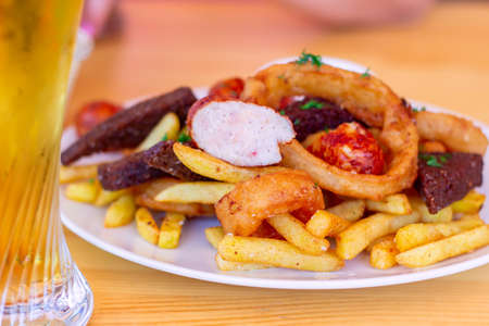 Meal for the Munich Oktoberfest with sausages, potato, cabbage and pretzels served with beer over stone backround. Selective focusの写真素材