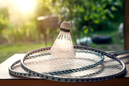 Badminton rackets and shuttlecock lie on the table in the gardenの写真素材