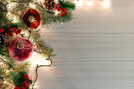 Christmas decoration with spruce branches with a red ball and a garland. Winter holiday light decorationの写真素材