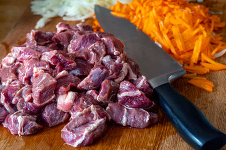 Beef meat, onions, carrots cutting board with a knife billet for pilaf.の写真素材