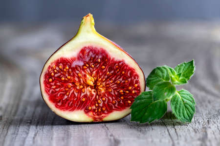 Fresh figs on the wooden table with mint leaves.の写真素材