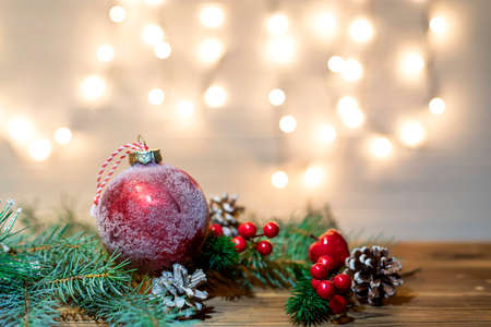 Christmas decoration with spruce branches with a red ball and a garland. Winter holiday light decoration.の写真素材