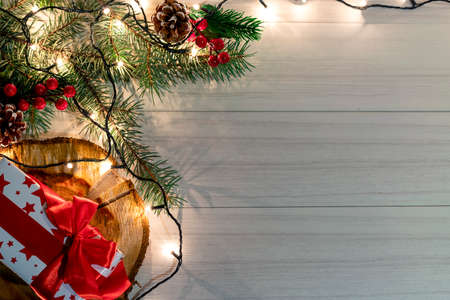 Christmas decoration with spruce branches with a red ball and a garland. Winter holiday light decoration. Top view.の写真素材
