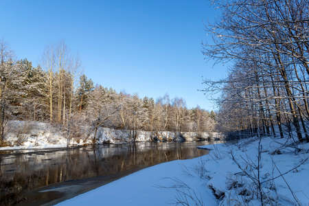 Landscape with winter forest and river. Sunrise, sunset in beautiful snowy forest