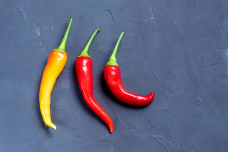 Variety of chili peppers. Red, green and yellow chili pepper on dark background top viewの写真素材