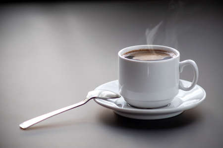 A cup of coffee with steam on the table. Planning and starting the day.の写真素材