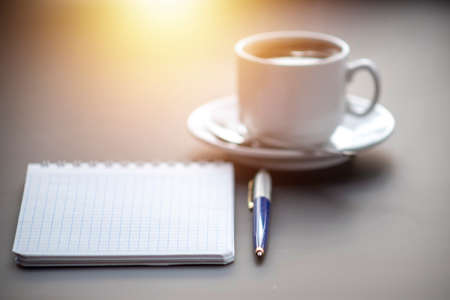 A cup of coffee with steam on the table. Planning and starting the day.の写真素材