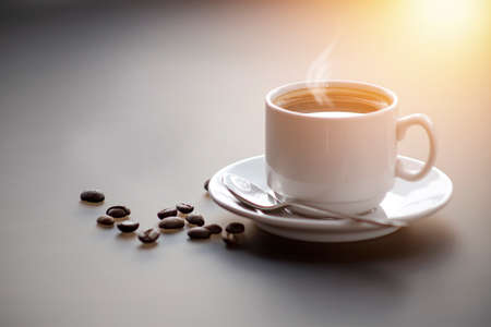 A cup of coffee with steam on the table. Planning and starting the day.の写真素材