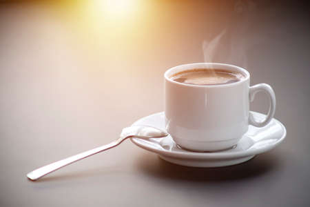 A cup of coffee with steam on the table. Planning and starting the day.の写真素材