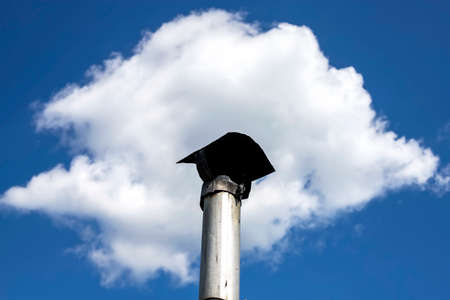 Clouds on the blue sky like a smoke from the chimney on the roof.の写真素材