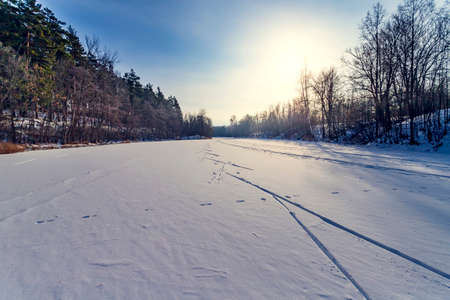 Sun, snow and Ski track crossing a frozen lake. Winter sportの写真素材