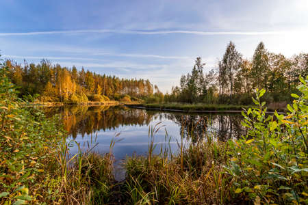 A lake in the middle of the forest. Warm autumn dayの写真素材