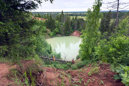 A green lake in the middle of the forestの写真素材