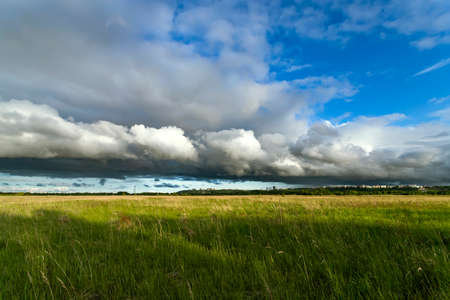 Dramatic clouds on the horizon in the field in spring time.の写真素材
