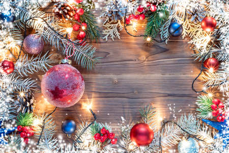 Christmas decoration with spruce branches with a red ball and a garland. Winter holiday light decorationの写真素材