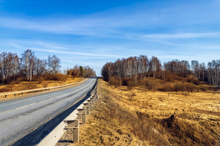 Asphalt road going through the countryside going into the distanceの写真素材