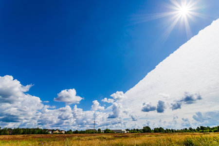 Two types of clouds over a field on a sunny summer dayの写真素材