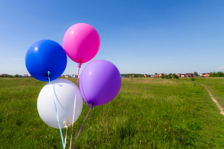 Multicolored inflatable balloons filled with helium against the blue skyの写真素材