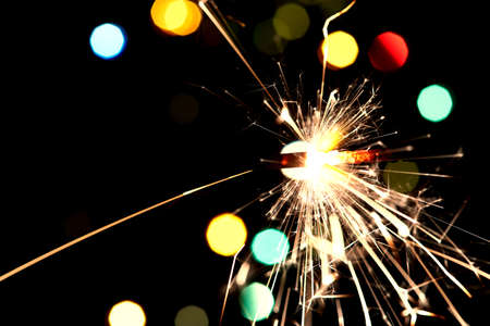 Bright holiday. Bengali fire burning on the background of beautiful bokeh. Concept Happy New Year and christmasの写真素材