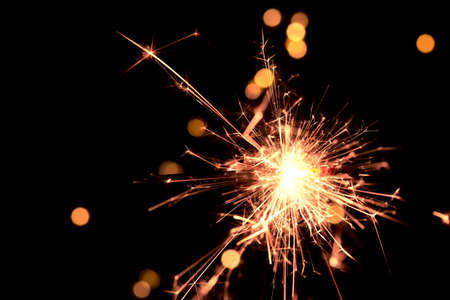 Bright holiday. Bengali fire burning on the background of beautiful bokeh. Concept Happy New Year and christmasの写真素材