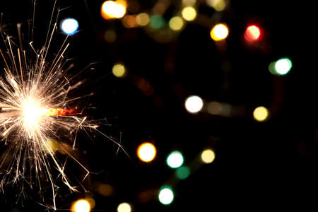 Bright holiday. Bengali fire burning on the background of beautiful bokeh. Concept Happy New Year and christmasの写真素材