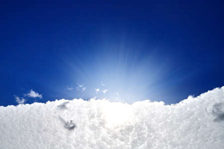 White clouds and sun on blue sky on a sunny dayの写真素材