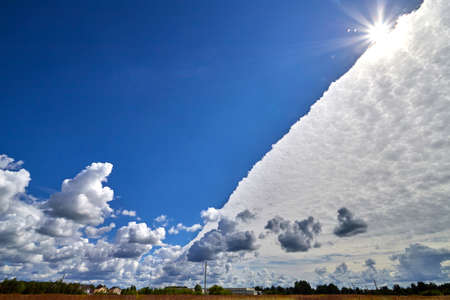 White clouds and sun on blue sky on a sunny dayの写真素材