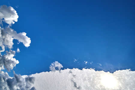 White clouds and sun on blue sky on a sunny dayの写真素材
