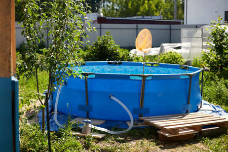 Metal frame pool. Frame pool stand on a green grass in the country in the sunny summer day.の写真素材