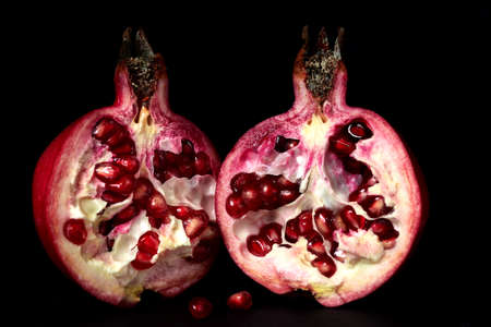 Red pomegranate berries closeup on black background.の写真素材