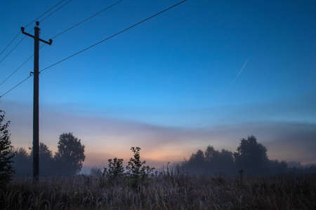 Silhouette of old electrical lines, old telephone cables and light at the golden hour on the sunrise.の写真素材